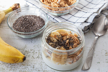 A healthy and healthy breakfast of homemade yoghurt with banana, muesli and chia seeds.