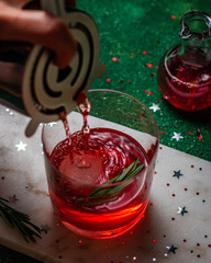 Christmas cranberry cocktail on marble and green background