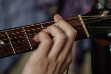 Hand playing on a guitar.