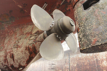 The screw of a sea-craft standing under repair in dock.