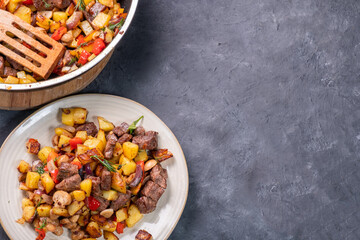 Fried potatoes with mushrooms, meat and mushrooms, homemade food. Top view, free space.