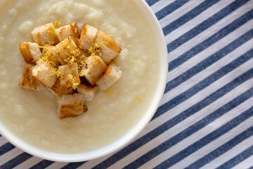 Homemade Cauliflower Soup with Croutons and Oil, top view. Flat lay, overhead, from above. Copy space.