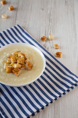 Homemade Cauliflower Soup with Croutons and Oil, side view. Space for text.
