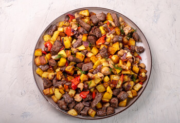 Large plate with fried potatoes, mushrooms and onions. View from above. White background.