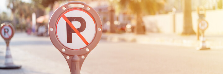 cone warning about a parking ban of automobile and cars. traffic safety sign on city street road....