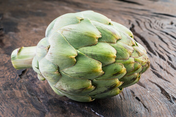 Fototapeta premium Artichoke flower edible bud on wooden background.