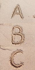 Alphabet (ABC) written on sand.