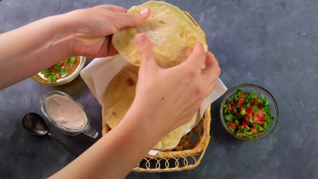 Homemade corn flatbread female hand cilantro greens tomato salsa. Handmade mexican tortillas vegetable salad Traditional Indian Punjabi Makki ki roti bread plate 4K Wheat flour dough authentic cuisine