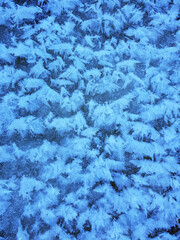 Snow crystals form beautiful snow pattern on frozen river. Snowflake background.