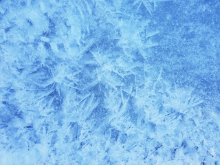 Snow crystals form beautiful snow pattern on frozen icy river. Snowflake background.