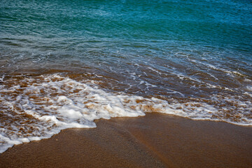 sea ​​background surf with foam on a sandy beach, horizontal
