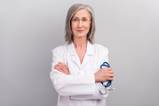 Photo of professional good mood lady doctor wear white coat spectacles holding phonendoscope smiling isolated grey color background