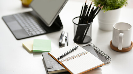 Simple office workspace with digital tablet, note books and stationery