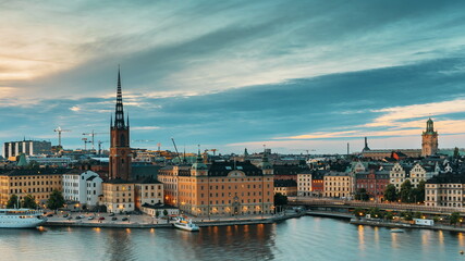 Fototapeta na wymiar Stockholm, Sweden. Scenic View Of Stockholm Skyline At Summer Evening. Famous Popular Destination Scenic Place In Dusk Lights. Riddarholm Church In Day To Night Transition Time Lapse