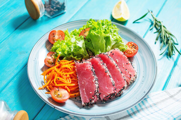 Salad with pieces of tuna and sesame with fresh vegetable salad on a plate. Authentic Japanese food