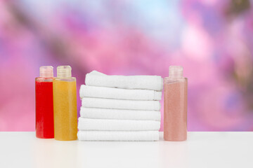 Spa still life with towels and skincare cosmetics against blurred background