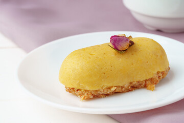 Mini mousse pastry dessert with rose on white plate