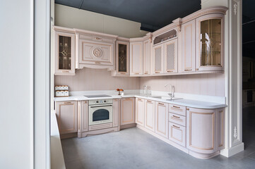 classic kitchen with oak facades in pink with carved elements and a white stone countertop