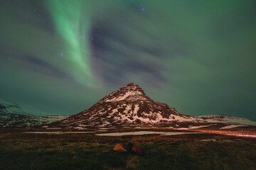 Magnifiques aurores boréales au dessus d'une montagne en Islande
