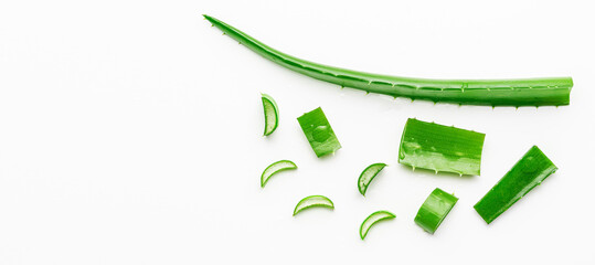 Aloe vera leaf with cut slices on white background. Copy space, flat lay.