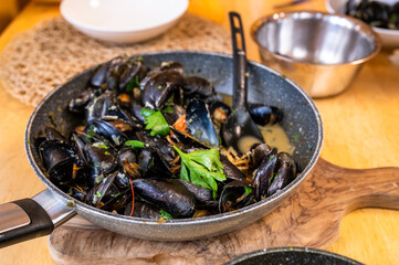 Boiled black mussels in wine and garlic in pan.
