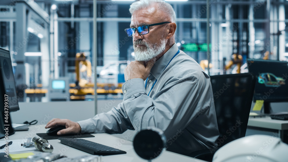 Poster car factory office: portrait of white male chief engineer working on desktop computer in automated r