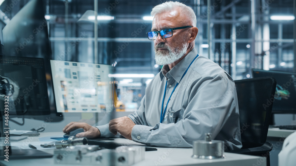 Poster car factory office: portrait of senior male chief engineer working on desktop computer in automated 