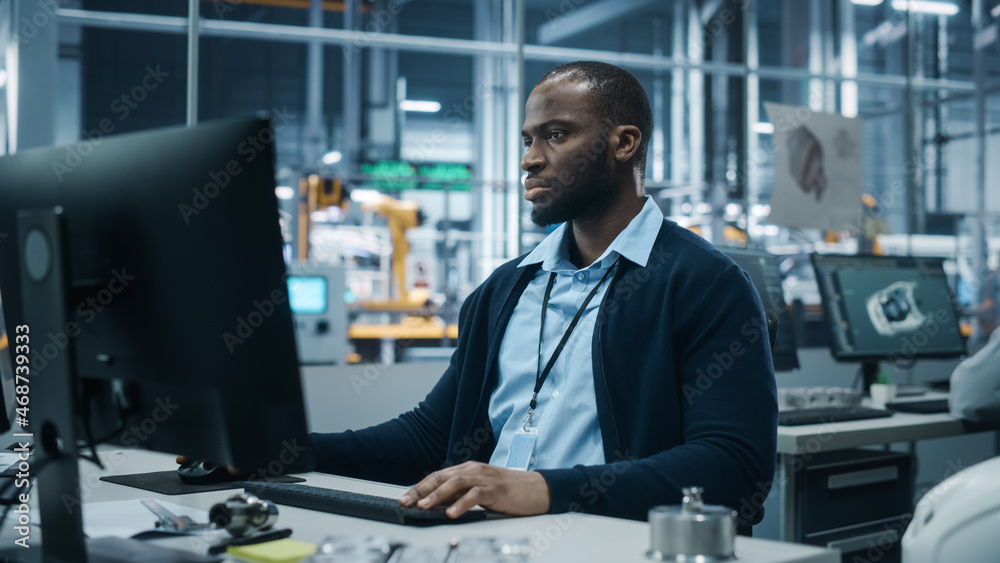 Poster car factory office: portrait of confident black male chief engineer working on desktop computer. pro