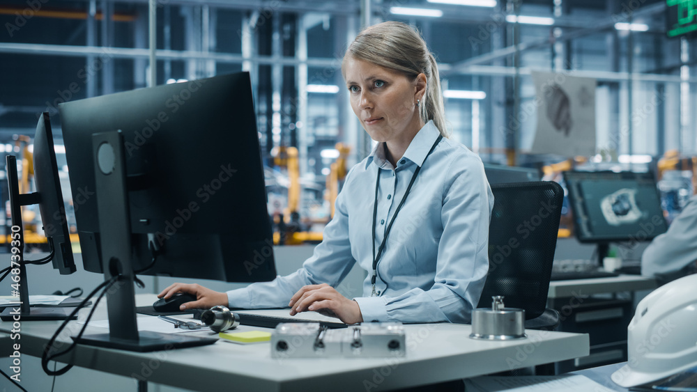 Poster car factory office: portrait of confident female chief engineer working on desktop computer. profess