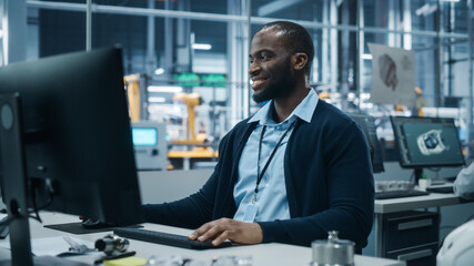 Fototapeta premium Car Factory Office: Portrait of Confident Black Male Chief Engineer Working on Desktop Computer. Professional Technician in Automated Robot Arm Assembly Line Manufacturing High-Tech Electric Vehicles