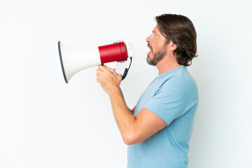 Senior dutch man isolated on white background shouting through a megaphone to announce something in lateral position