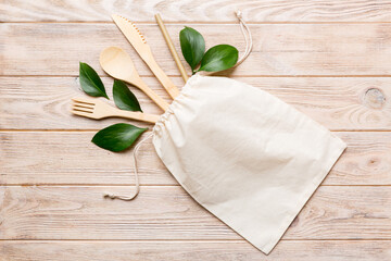 Eco friendly reusable recyclable white eco bag with kitchenware on Colored background. Concept zero waste.