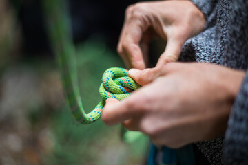 Climber's hands tying a figure eight know to the harness