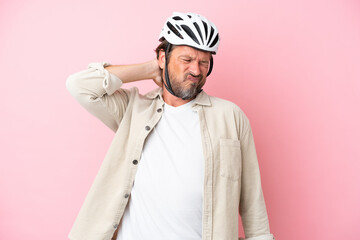 Senior dutch man with bike helmet isolated on pink background with neckache
