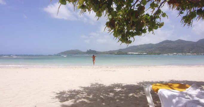 Wide Scenic View of Latino Lady Return from Swim in Sea on Tropical Beach Resort Playa Teco Maimon, gentle zoom