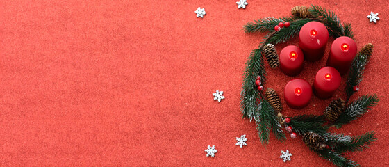 big red banner of Christmas with wreath from spruce branches and red candles on red background. Space for text, top view. New year mood, festive concept. Christmas table. gift card  © Vera
