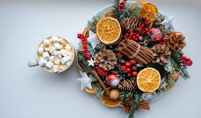 Fototapeta na wymiar cocoa cup, nuts, cinnamon, cones, berries, orange citrus, apples on white table. Christmas and new year holiday. traditional festive winter composition with Christmas natural decor. flat lay