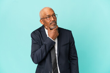 Business senior man isolated on blue background having doubts