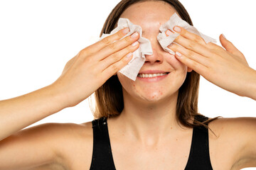 a young smiling woman cleans her face with wet tissue