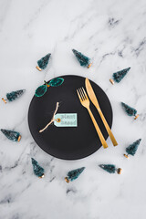 plant-based label on top of black dining plate with Christmas decorations all around on marble table, healthy nutrition and vegan Christmas food