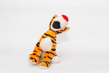 Toy striped cute tiger a symbol of the New year. soft orange toy tiger on a white isolated background.Copy space, closeup, selective focus. The concept of welcome to 2022.