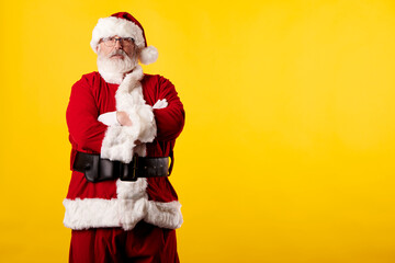 Fototapeta na wymiar Santa Claus with crossed arms on a yellow background