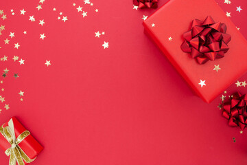 Christmas red gifts on red background, festive holiday decorations, copy space. Golden glitter.