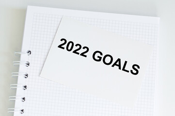 2022 business goal text on the card next to the notebook on the table, vision to success