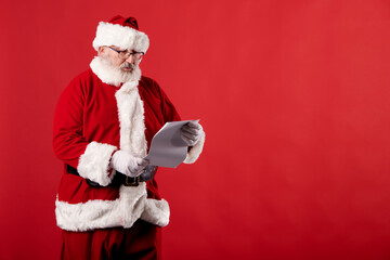 Fototapeta na wymiar Santa Claus reading a letter on red background