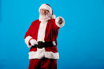 Santa Claus pointing his finger at the camera on a blue background