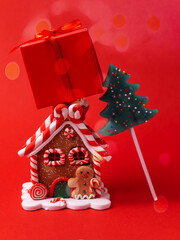 Gingerbread house, red clock, gift, lollipop, candy on a red background.