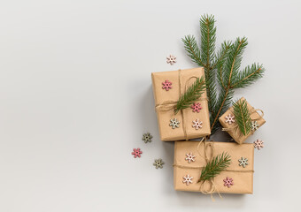 Winter holiday composition. Handmade wrapped gifts for Christmas or New Year with fir tree branches and decoration. Flat lay, copy space.