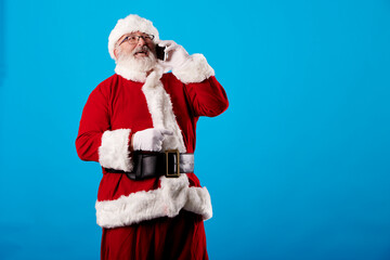 Santa Claus using a mobile phone on blue background