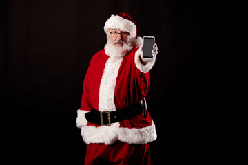 Santa Claus using a mobile phone on black background